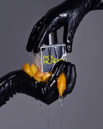 Close-up of hands in black glossy gloves holding a perfume bottle dripping with dark liquid and peach slices