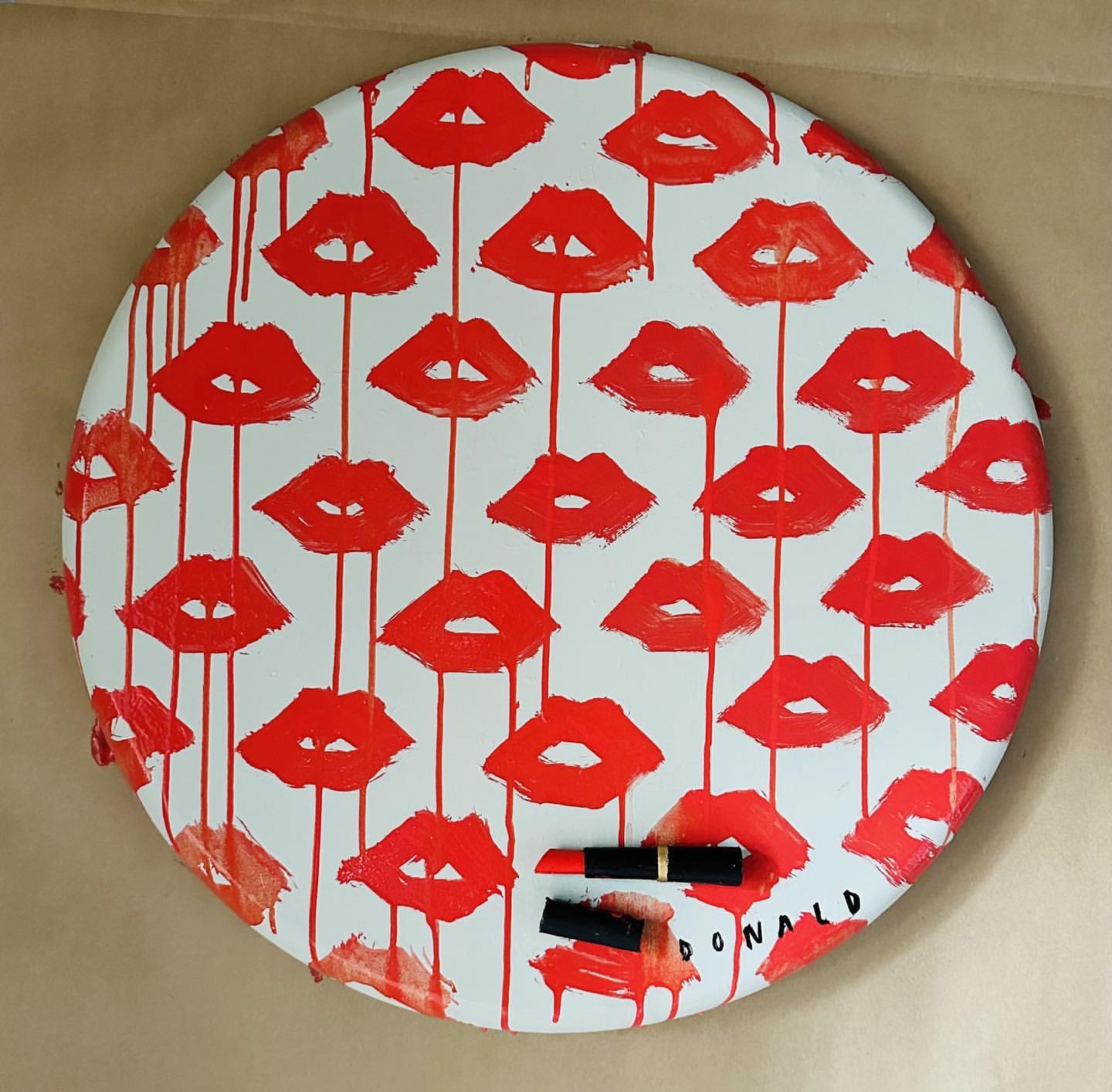 Graphic art featuring a repeating pattern of vibrant red lips with lipstick accents on a white surface, minimalist and eye-catching.