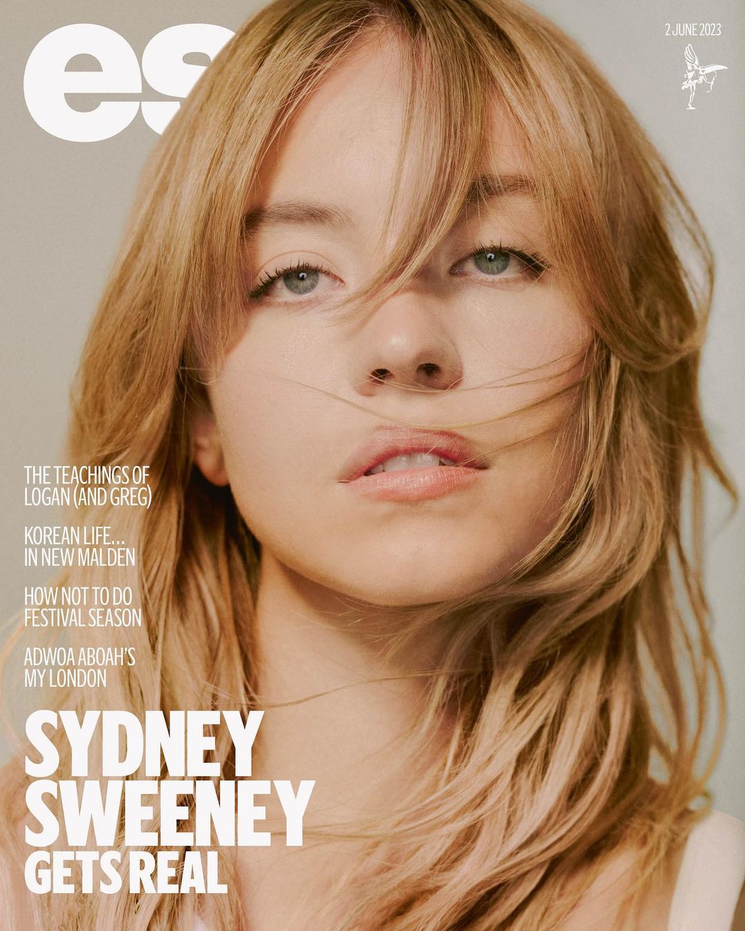 Close-up portrait of Sydney Sweeney on magazine cover. She has blond hair, blue eyes, and a neutral expression. The magazine text reads Sydney Sweeney Gets Real.