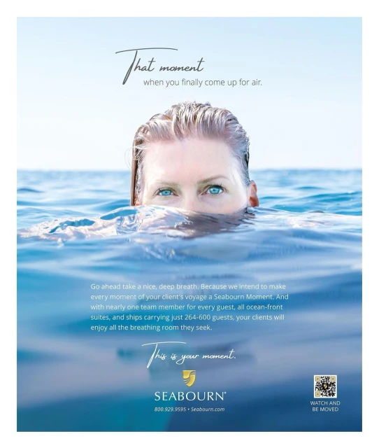 Woman's face and shoulders emerge from clear blue water in bright daylight, creating a refreshing ocean scene, promotional in style.