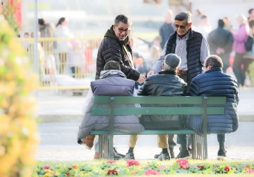 Five men gathered around a park bench outdoors, captured by photographer Doug Menuez in New York.