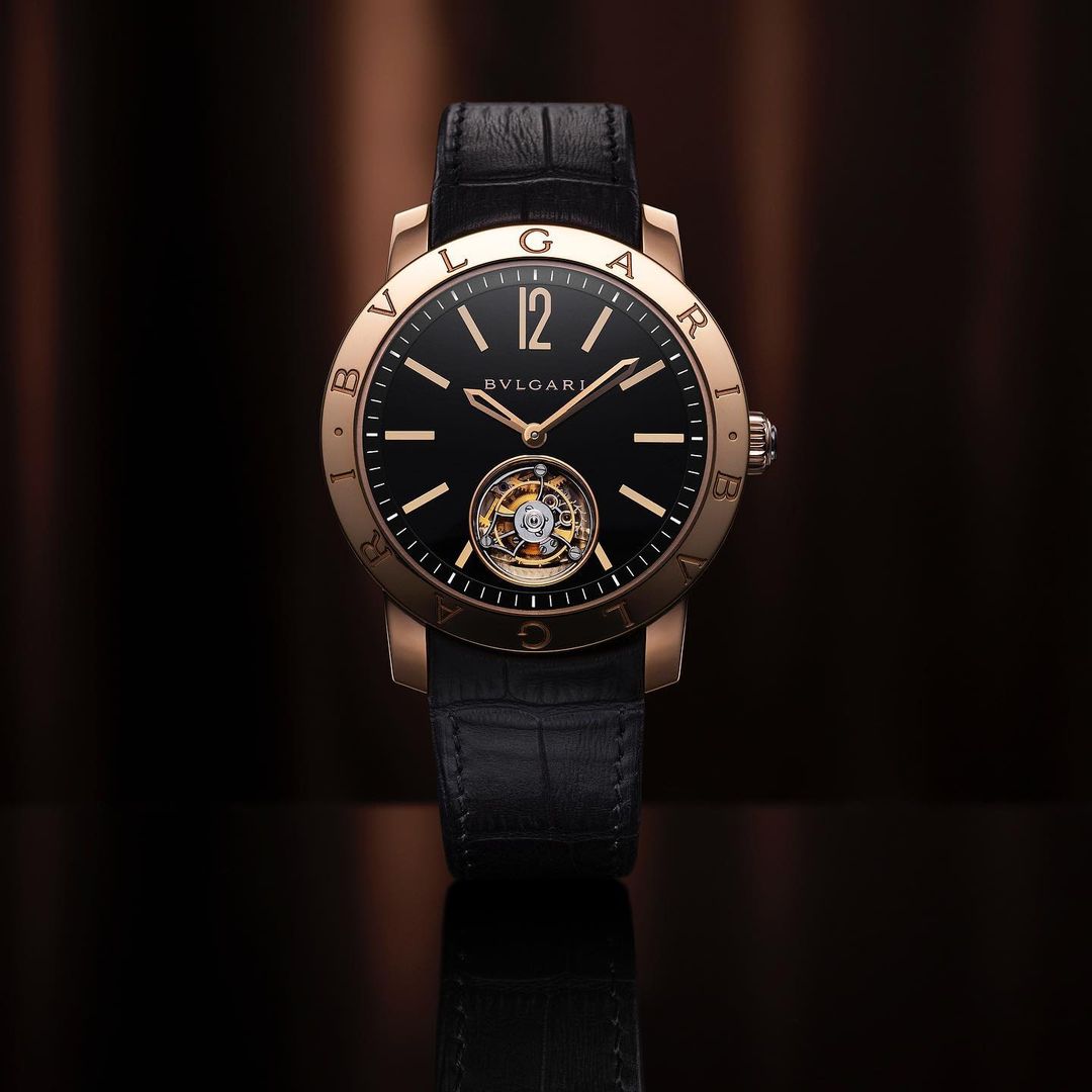 Bulgari Octo Tourbillon watch. Elegant black dial timepiece with rose gold case and black leather strap on a dark background.