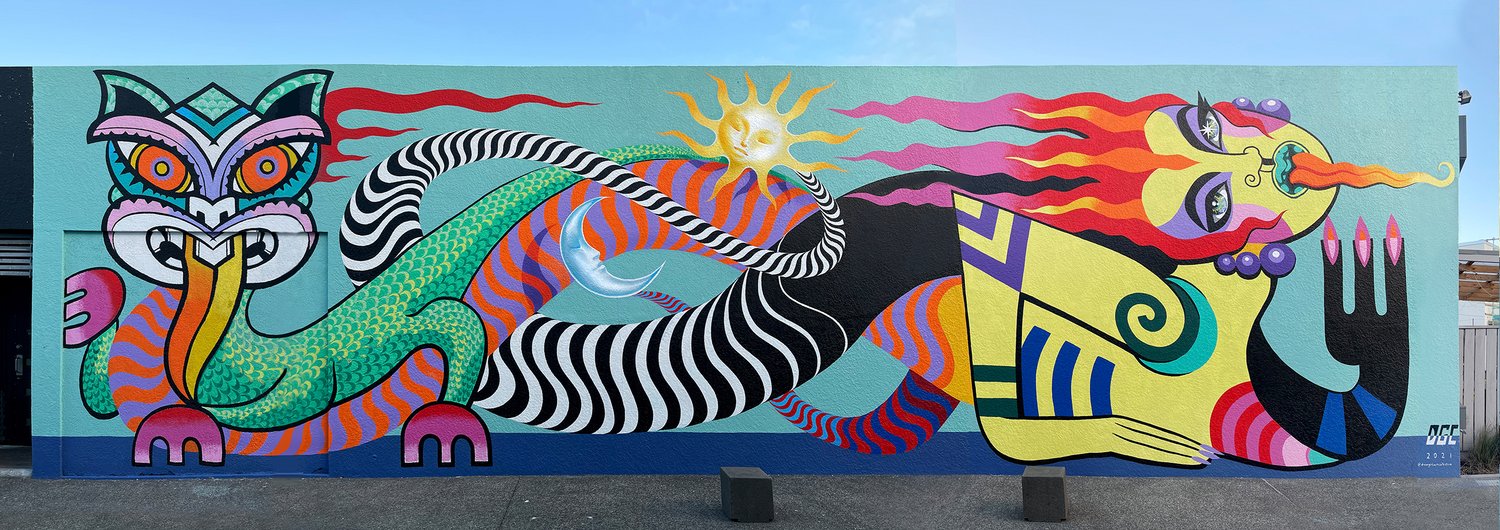Vibrant mural art on an exterior wall featuring a colorful mythical creature, sun with a face, and abstract design elements.