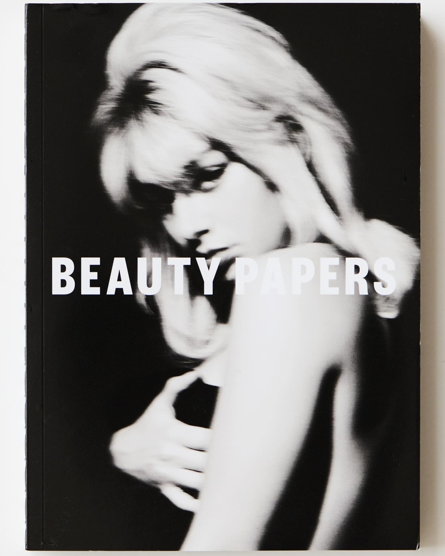 Monochrome magazine cover featuring a woman with voluminous blonde hair and bold typography reading BEAUTY PAPERS.