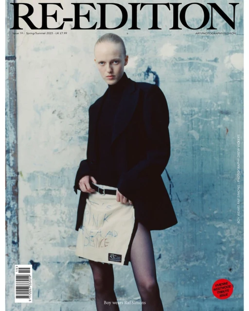 Fashion magazine cover featuring a model in a black top and unique skirt, set against a textured wall with bold magazine typography.