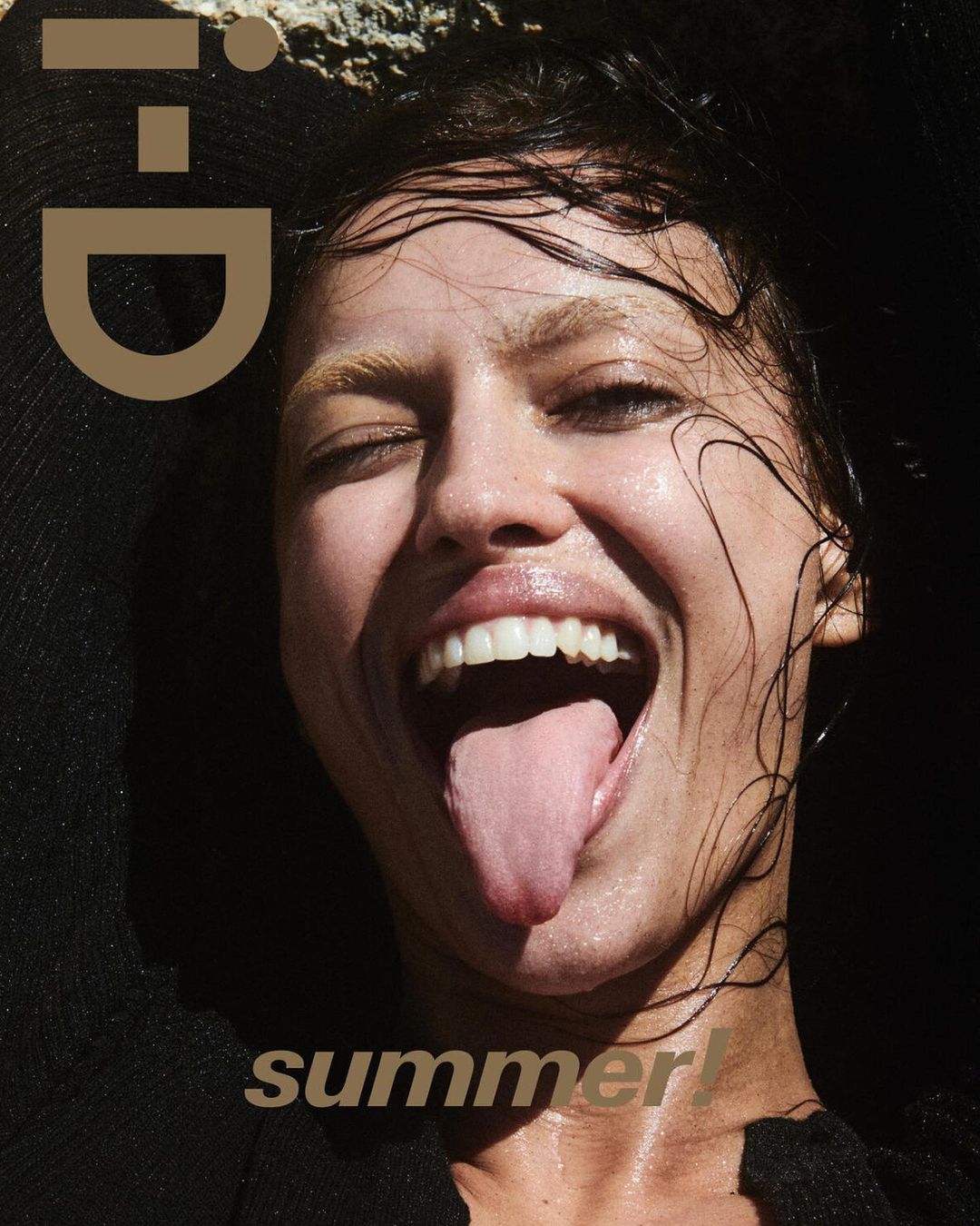 Close-up portrait of a woman with wet hair sticking out her tongue, photographed by Drew Vickers.