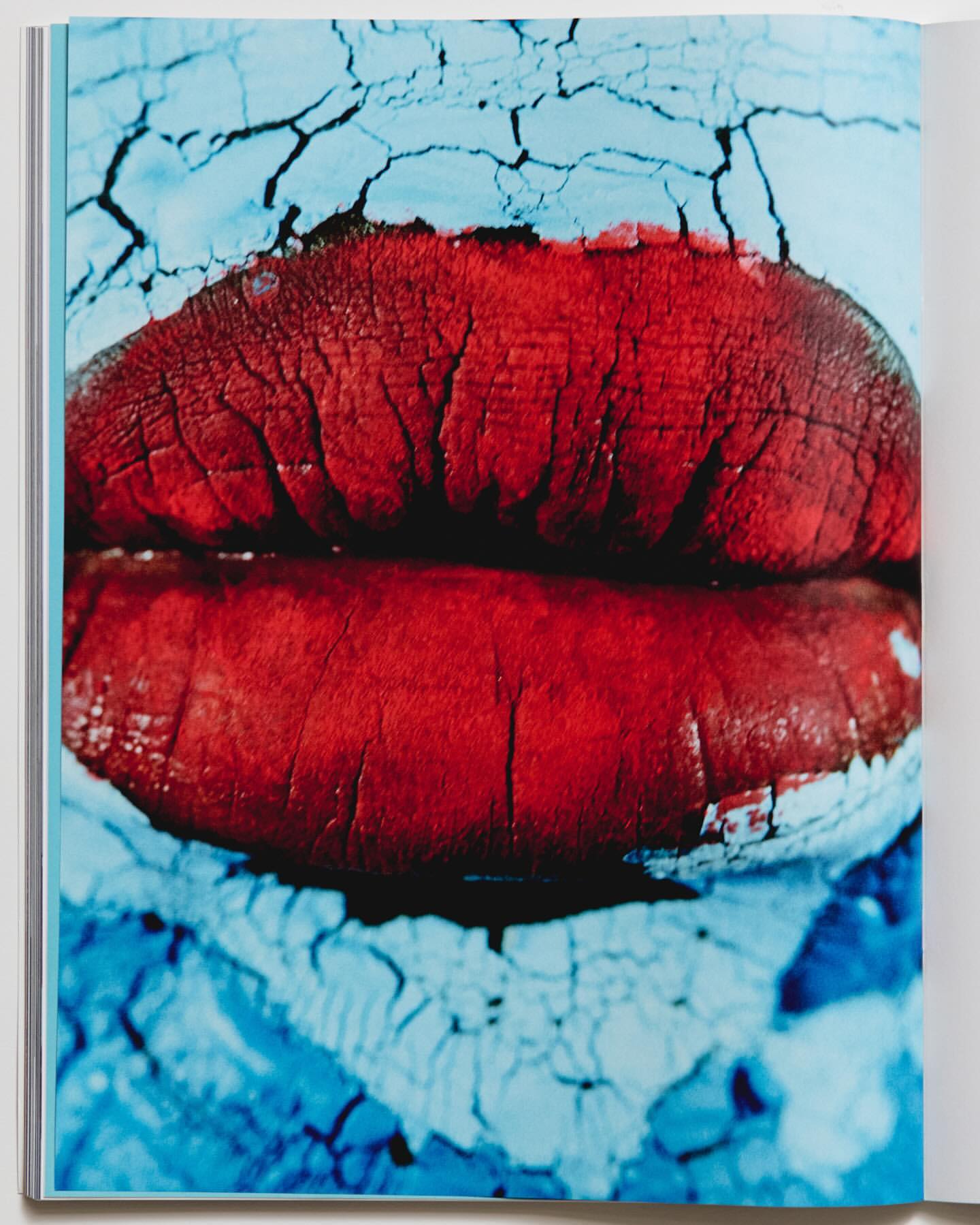 Close-up macro shot of chapped red lips against a cracked light blue textured background