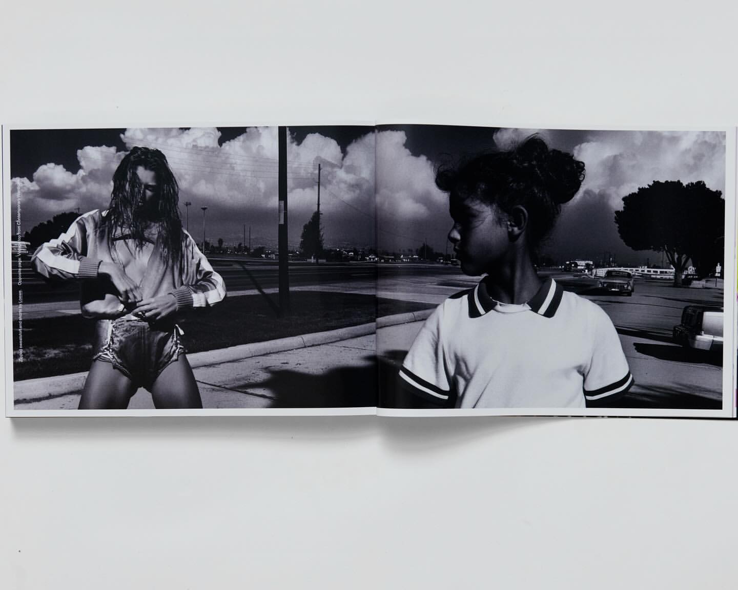 Black and white photograph featuring a fair-skinned young adult and an African-American child in an outdoor, urban setting, seemingly captured from a book.