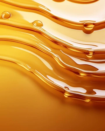 Abstract close-up of flowing, viscous liquid in shades of amber and gold, creating a sense of depth and movement with small drops.