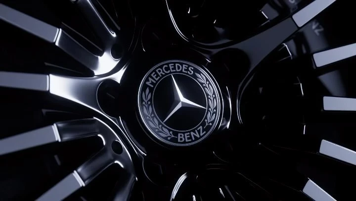Close-up of a Mercedes-Benz wheel, highlighting the iconic logo in the center of the polished, black car part, creating a sleek auto detail.