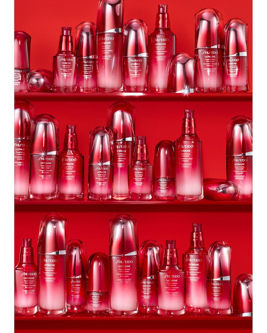 An array of red and white SHISEIDO ULTIMUNE skincare product bottles displayed on three shelves in a brightly lit studio environment.