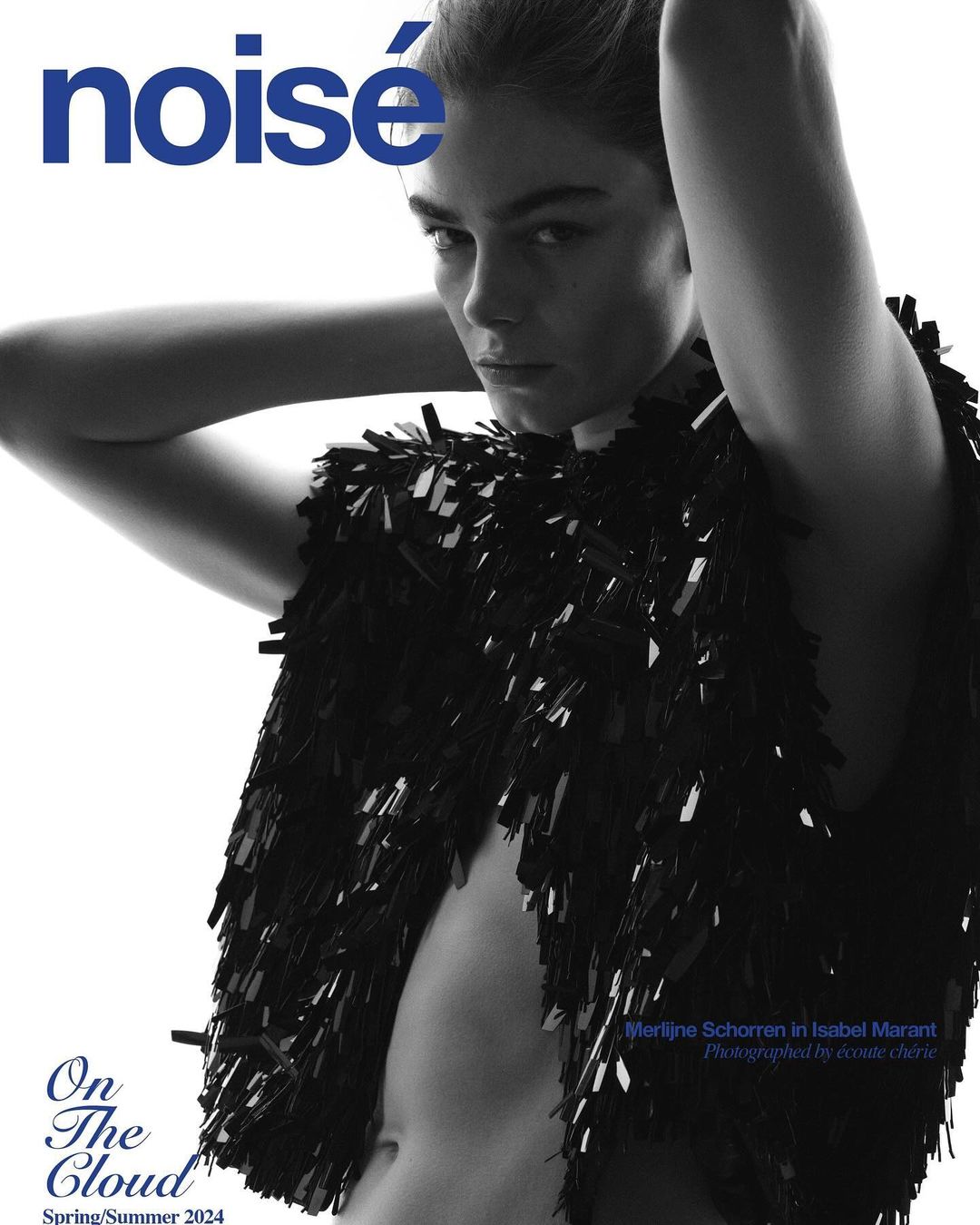 Magazine cover featuring a young woman with dark hair, wearing a black fringed vest against a bright white background, minimal makeup.