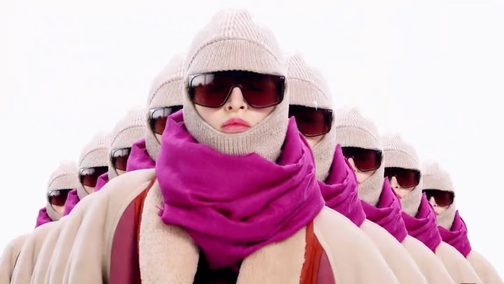 Multiple women in beige knit balaclavas and large sunglasses with pink scarves against a bright white background for fashion.