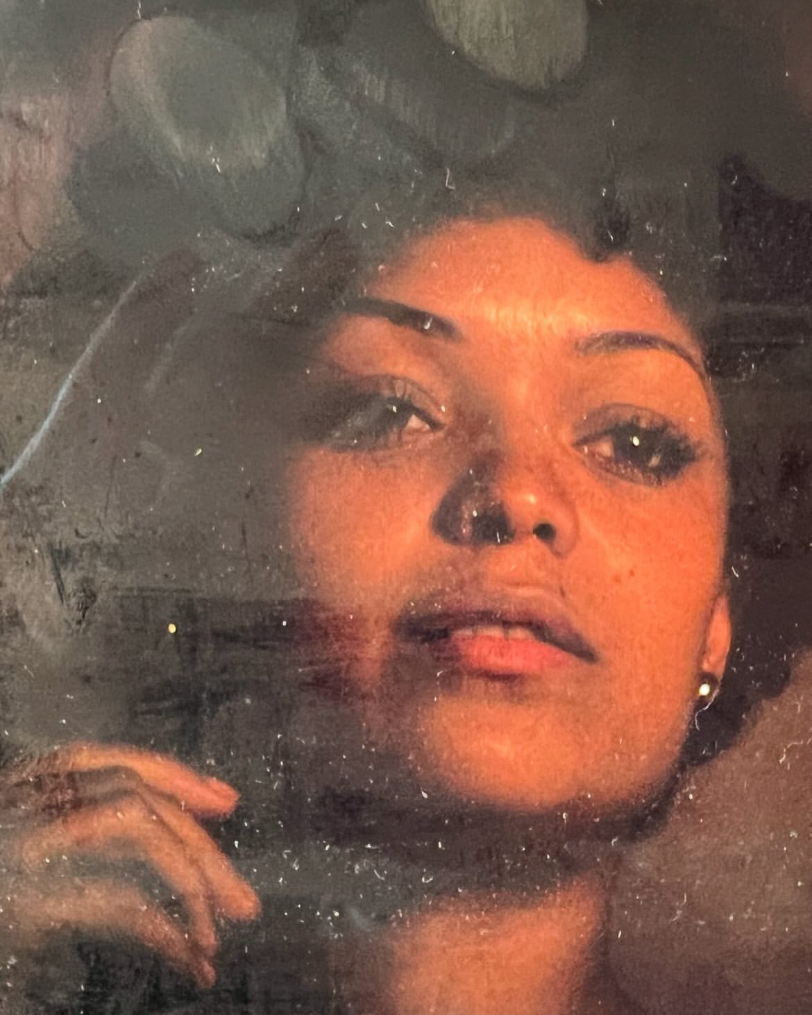 Portrait of a woman with dark hair looking upward, indoor with dark background; beauty, hair styling and portrait photography.