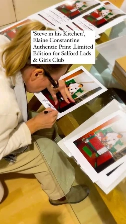Adult signing authentic print 'Steve in his Kitchen' by Elaine Constantine, a limited edition for Salford Lads & Girls Club. 