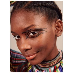 Close-up portrait of a young Black woman with braided hair and graphic black eyeliner by Elaine Constantine