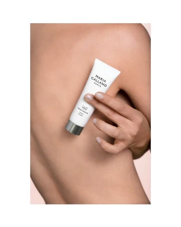 Woman's back with hand holding Maria Galland Paris skincare cream tube; close-up product shot for beauty and skincare advertising.