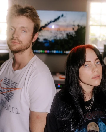 Billie Eilish and Finneas O'Connell posing indoors for a portrait photograph by Elizabeth Weinberg in New York.