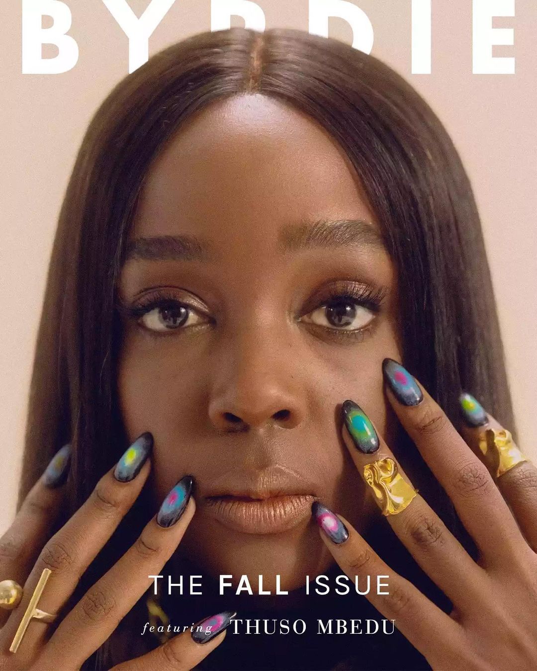 Close-up portrait of Thuso Mbedu with long dark hair, featuring artistic painted nails and gold rings by Elizabeth Weinberg.