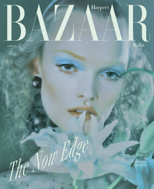 Harper's Bazaar Italia cover featuring a model with blue eyeshadow, a pale flower, and black statement earrings, shot in a studio.