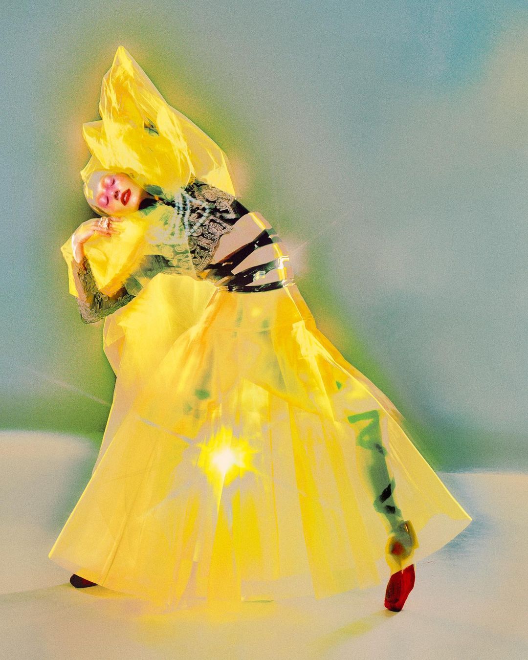 Person in yellow haute couture with light effects, posing in studio. High fashion editorial shot, face art, abstract, conceptual design.