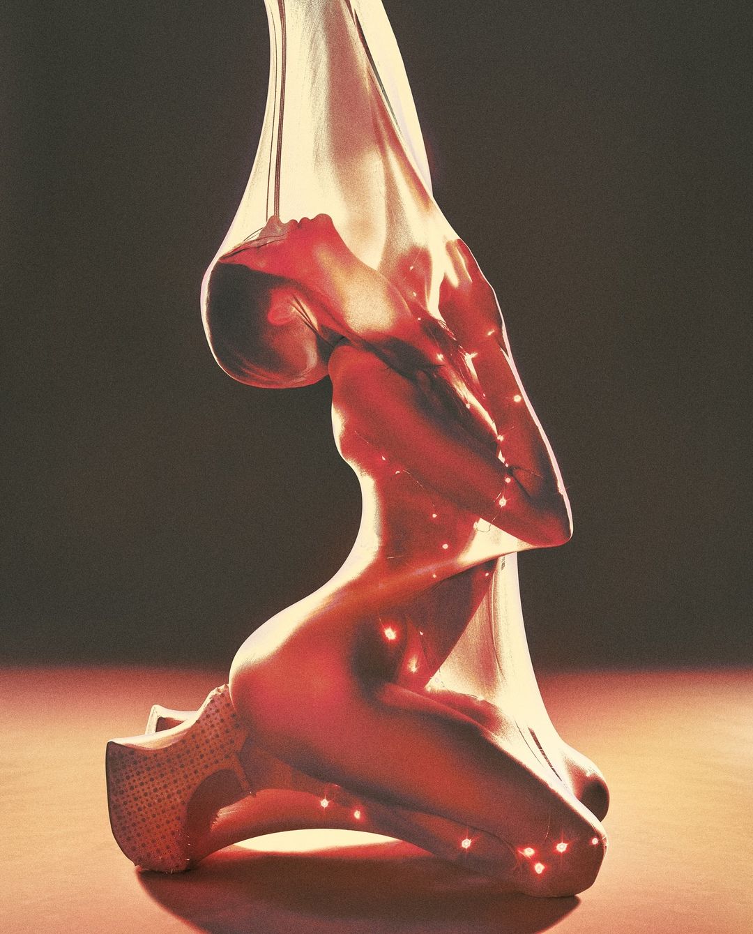 Abstract image of a woman kneeling, draped in semi-transparent material with red light accents, on a reflective surface.