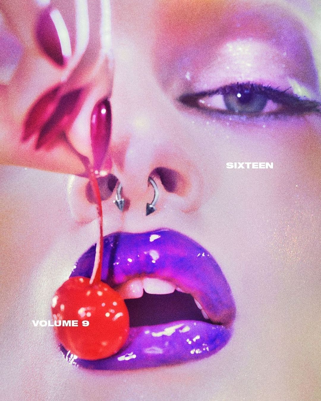 Close-up of a woman's face with vibrant purple lips, nose piercings, and a red cherry dangling from her mouth, creating a surreal aesthetic.