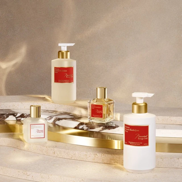 Four Baccarat Rouge 540 body care products arranged on a textured surface, including lotions and perfume, showcasing luxury beauty.