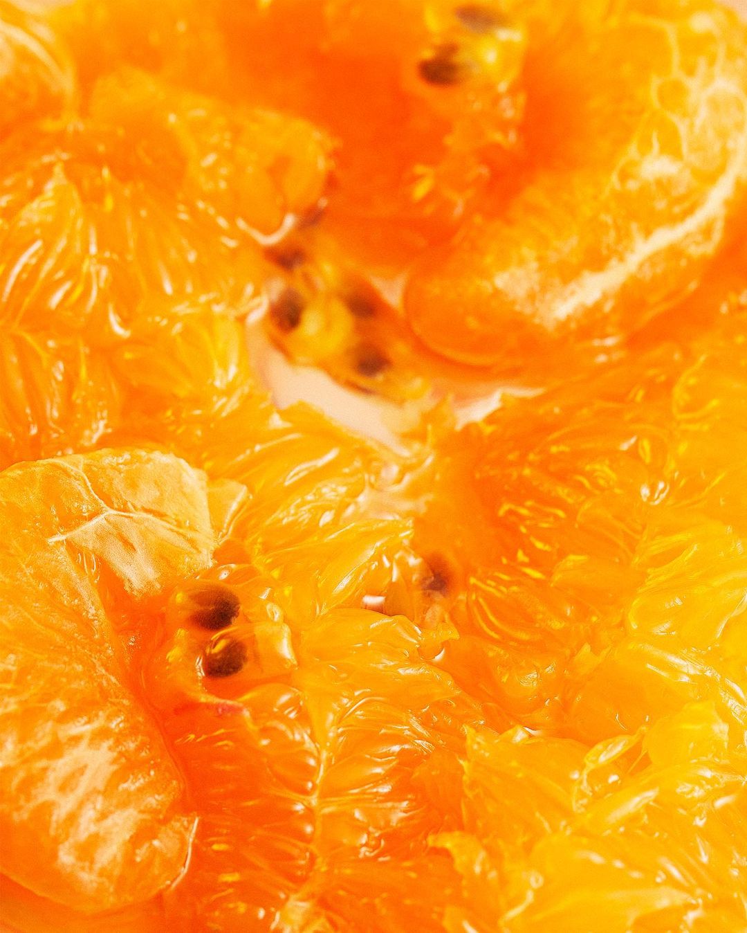 Close-up view of sliced oranges and seeds in a bowl, bright and vibrant colours and textures. Food and drink photography.