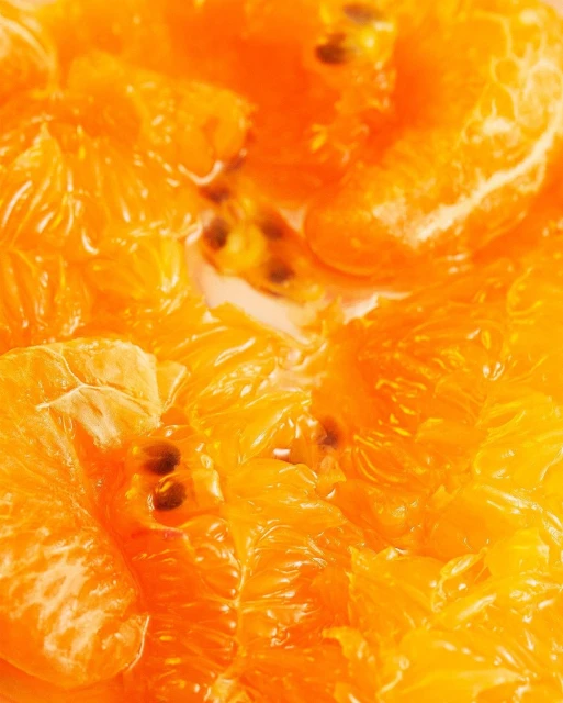 Close-up view of sliced oranges and seeds in a bowl, bright and vibrant colours and textures. Food and drink photography.