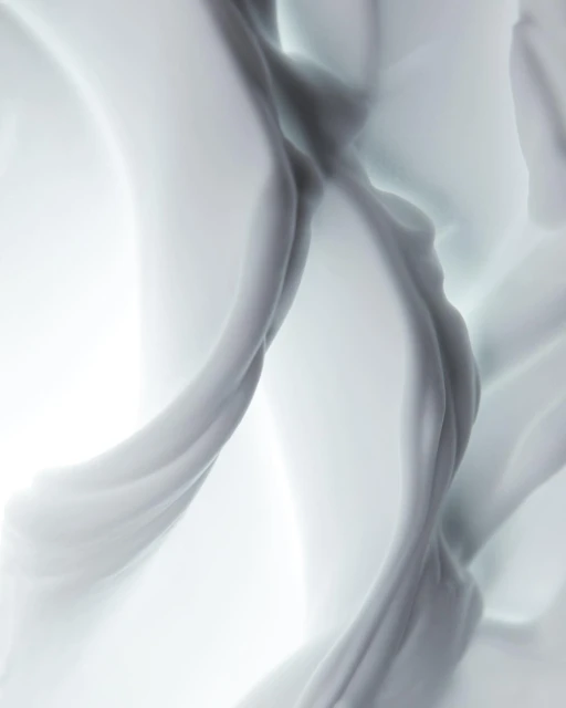 Abstract, swirling fabric in shades of white and grey creates a visually soft and flowing composition with a bright background.