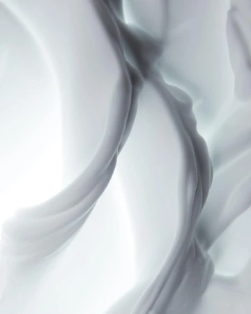 Abstract, swirling fabric in shades of white and grey creates a visually soft and flowing composition with a bright background.