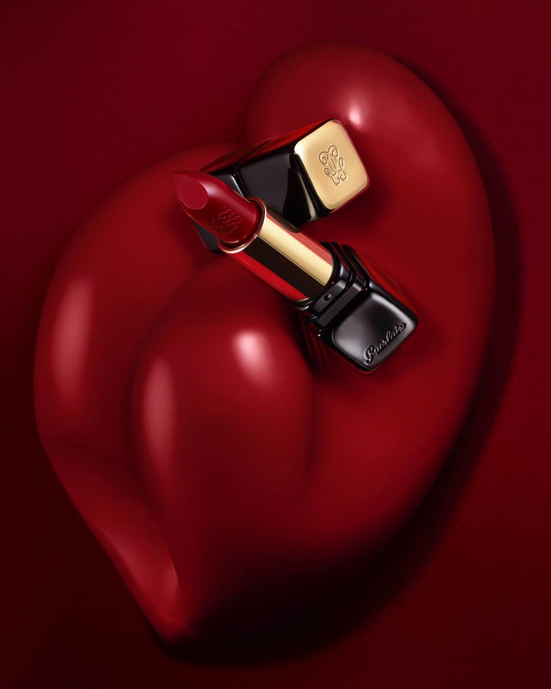 Guerlain lipstick on a red heart-shaped surface. Luxurious makeup product in a close-up studio shot. Cosmetics and beauty concept.