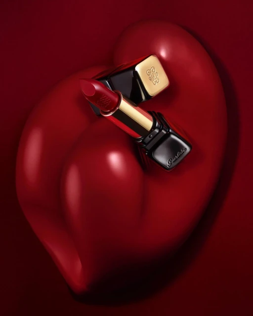 Guerlain lipstick on a red heart-shaped surface. Luxurious makeup product in a close-up studio shot. Cosmetics and beauty concept.