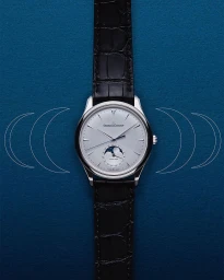 Luxury wristwatch with a black leather strap and silver dial centered on a dark textured blue background.