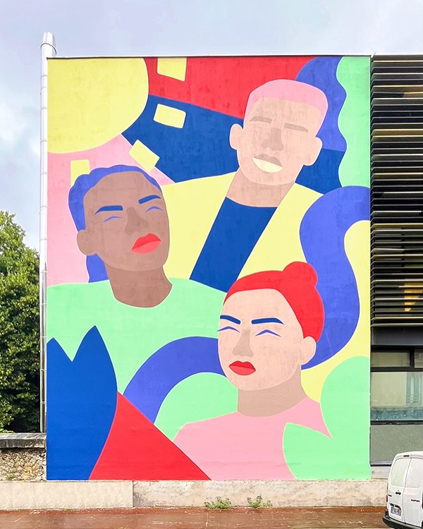 Vibrant mural featuring stylized portraits of three people against a colorful abstract background on the side of a building.