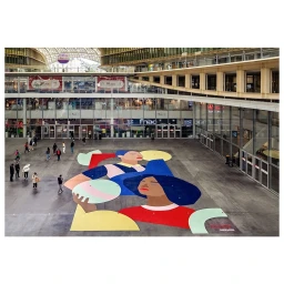 Large colourful floor mural artwork by illustrator Elsa Martino inside a multistory shopping centre atrium in Paris.