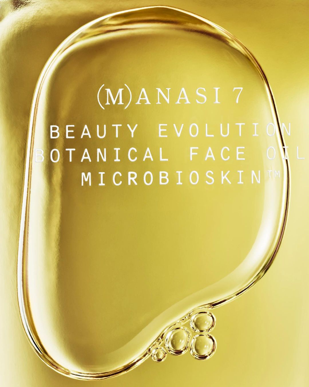 Close-up of Manasi 7 Beauty Evolution Botanical Face Oil featuring a clear, viscous liquid and product text on a gold surface.