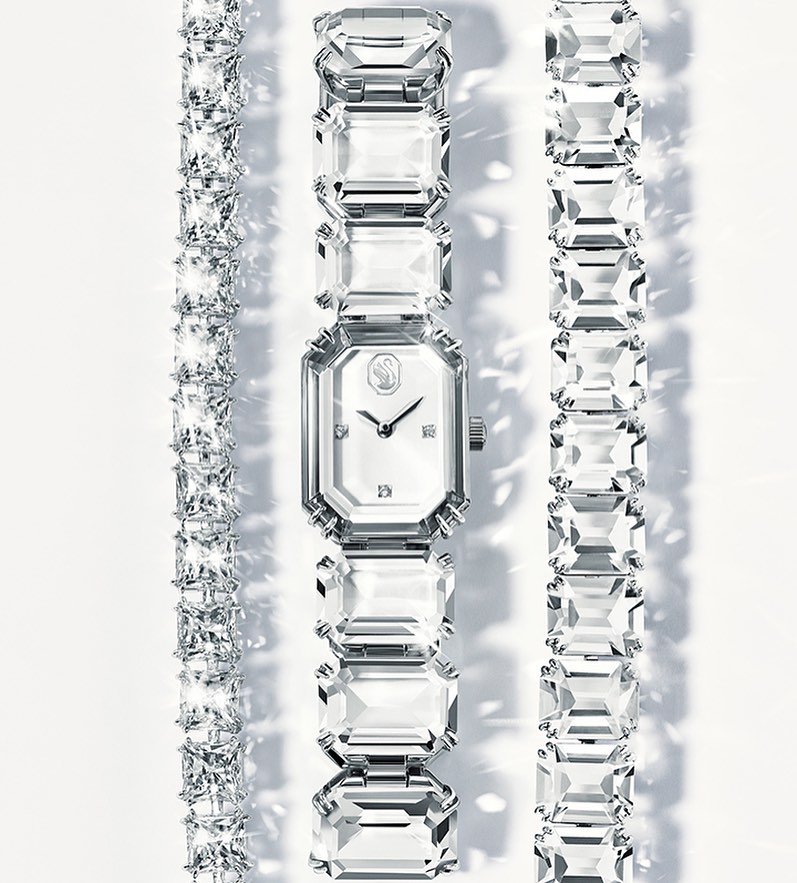 Sparkling Swarovski watch and bracelets on a white background, showcasing jewelry fashion and luxurious accessories.
