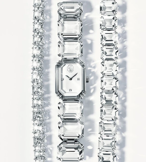 Sparkling Swarovski watch and bracelets on a white background, showcasing jewelry fashion and luxurious accessories.