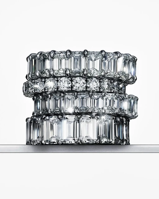Stack of four eternity rings featuring clear diamonds in varying cuts on a white background, jewellery photography.
