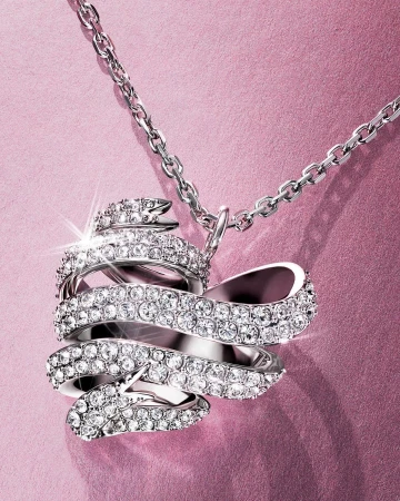 Sparkling crystal pendant necklace with a silver chain and a pink backdrop. Elegant jewelry design for fashion or special occasions.