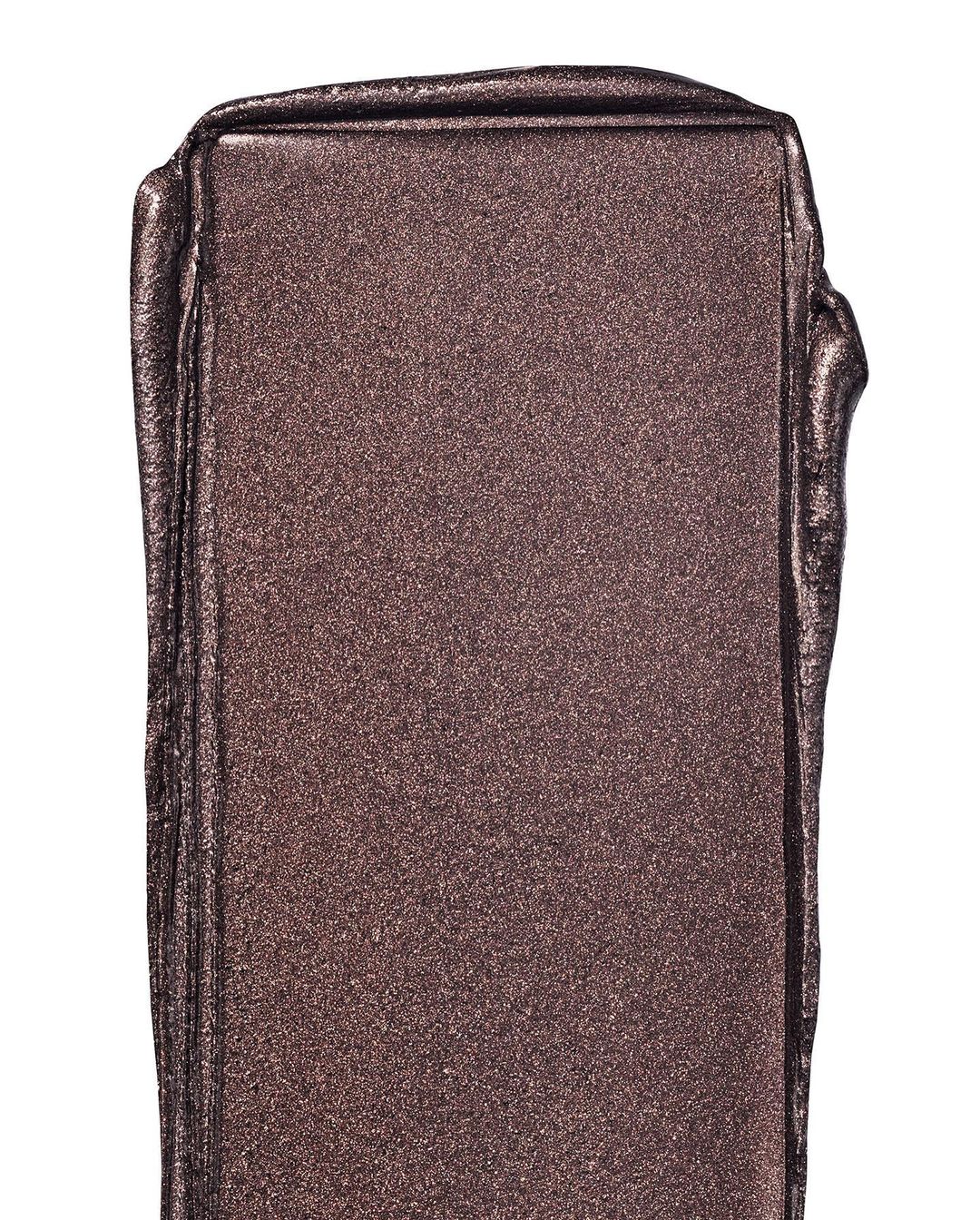Close-up of shimmering bronze-colored makeup swatch, capturing its reflective texture and rich pigment on a white backdrop.