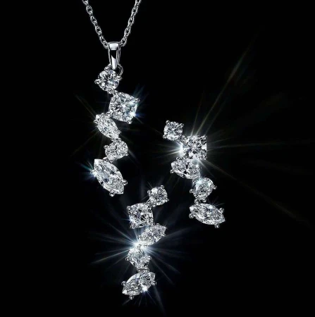 Elegant jewelry set on a black background showcasing a silver necklace and matching earrings adorned with sparkling, clear gemstones.