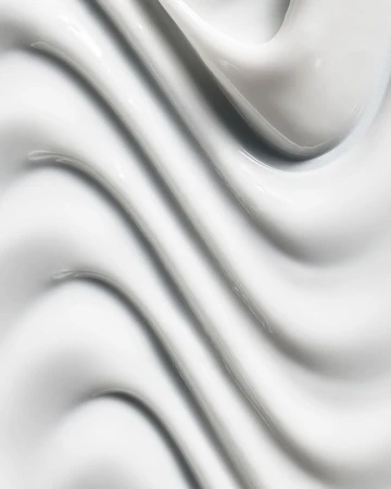 Close-up abstract texture of thick, smooth, glossy white cream or lotion with curving ridges and shadows filling the entire frame.