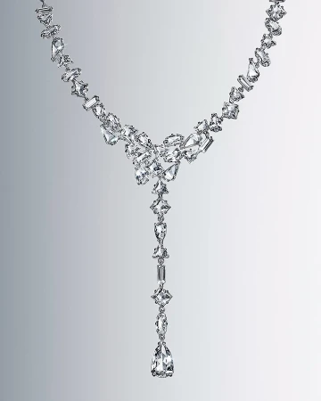 Elegant, long necklace features a graduated design with clear crystals in various geometric shapes on a gradient gray background.