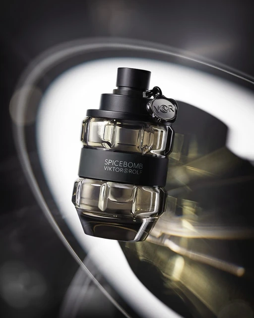 Viktor & Rolf Spicebomb bottle on a reflective surface with dramatic lighting creating abstract light trails in the background.