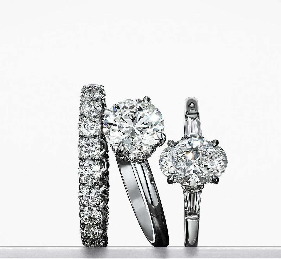 Three diamond rings are displayed against a gradient white background, showcasing sparkle and craftsmanship in a clean, elegant composition.