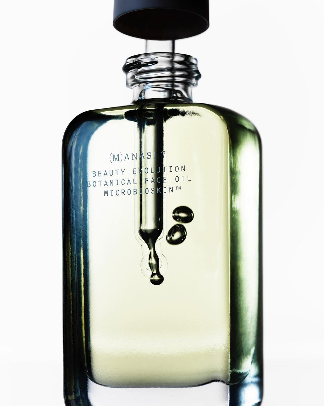 Close-up of a glass bottle of botanical face oil with a dropper, showcasing the product's natural ingredients and skincare benefits.