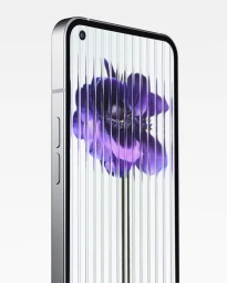 Close-up product shot of a silver smartphone showing a purple flower wallpaper on its screen against a seamless white background.
